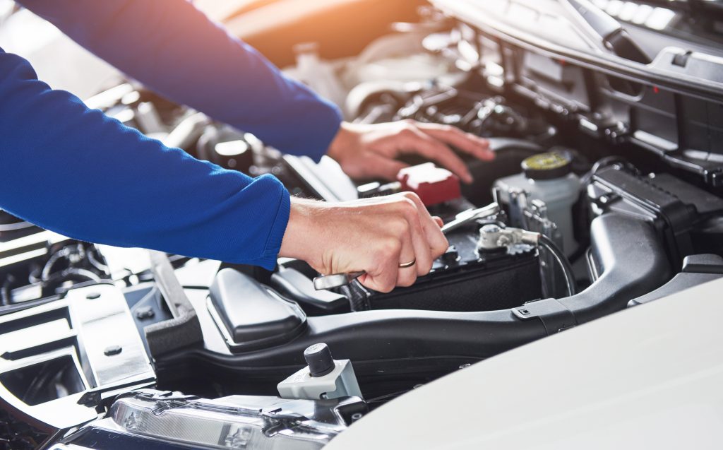 Ford technician inspecting engine during service in Shallotte, NC